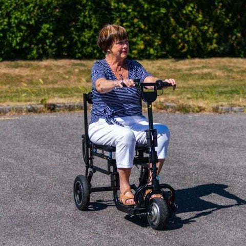 Lady riding the eFoldi Lite Lightweight Mobility Scooter Outdoors