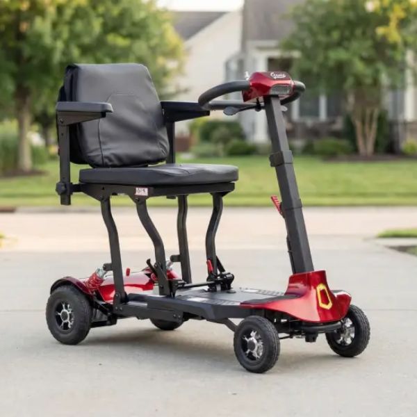 Genie Lightweight Folding Mobility Scooter parked on a paved driveway with a blurred suburban background.