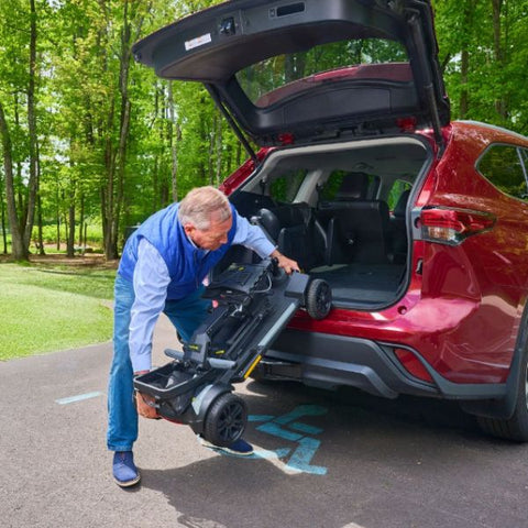 A man putting the Buzaaround CarryOn HD scooter in the Trunk