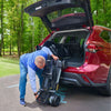 Image of A man holding the Buzzaround CarryOn HD about to lift it