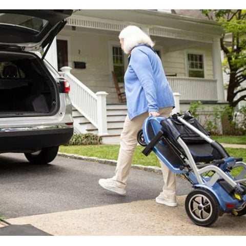 Lady dragging the Journey So Lite™ Lightweight Folding Scooter towards the back trunk of a car