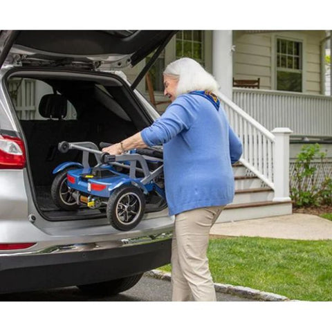 Lady storing away the folded up Journey So Lite™ Lightweight Folding Scooter in the back trunk of a car