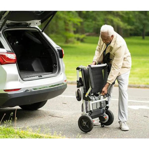 Man folding the Journey Zoomer Chair to store it in the back of a car