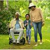 Image of Man riding the Journey Zoomer Chair outdoors being accompanied by others