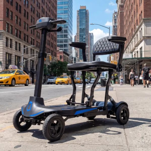 Supa Carbon Lite Ultra Lightweight Folding Mobility on the Road with Buildings at the Background