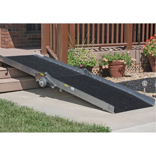 PVI Wheel-A-Bout Portable Wheelchair Ramp on a driveway with plants and a wooden deck in the background