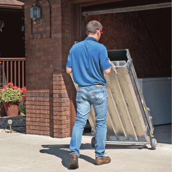 Man pushing the PVI Wheel-A-Bout Portable Wheelchair Ramp outside a building.