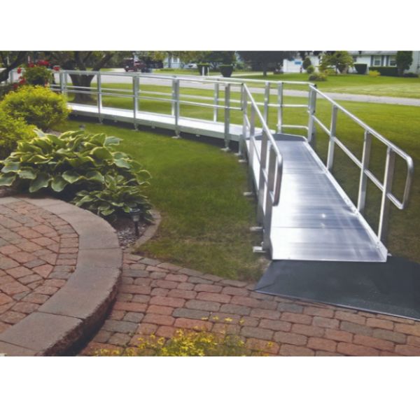 PVI XP Modular Wheelchair Ramp with Handrails leading to a driveway with grass and plants in the background