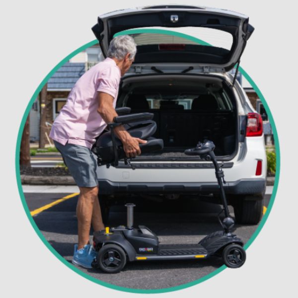 An older man is loading a Pride Go-Go Ultra X Gen 3 mobility scooter into the trunk of a white SUV. 