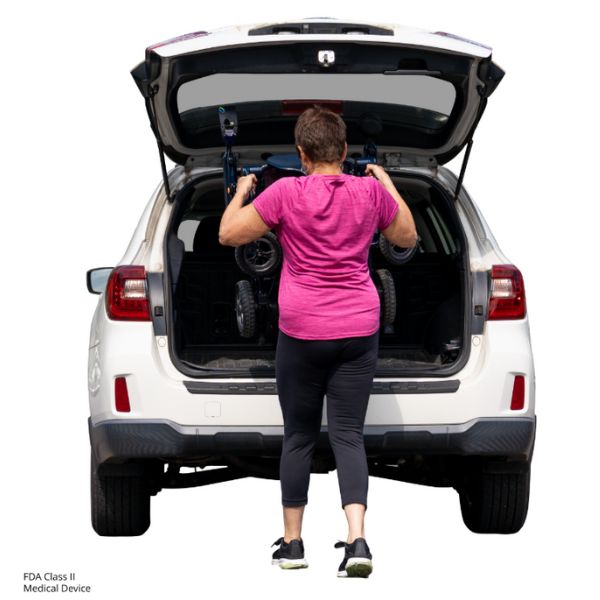 Person loading a Pride Jazzy Carbon 27 Folding Power Wheelchair into the trunk of a white SUV.