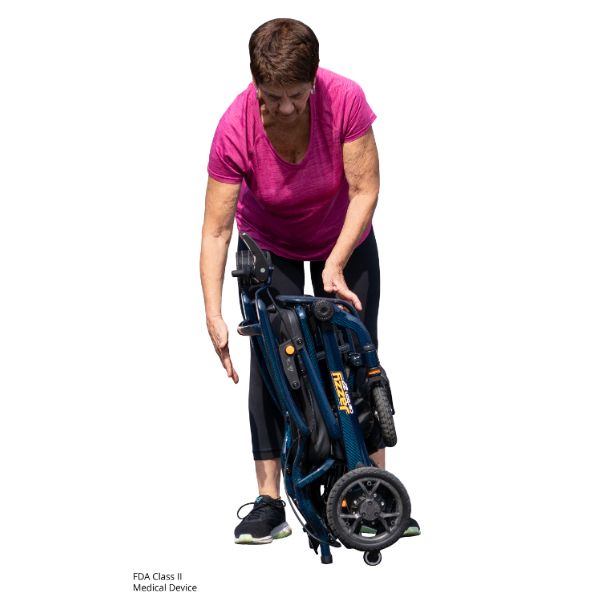 A woman holfing the Pride Jazzy Carbon 27 Folding Power Wheelchair that has been folded.