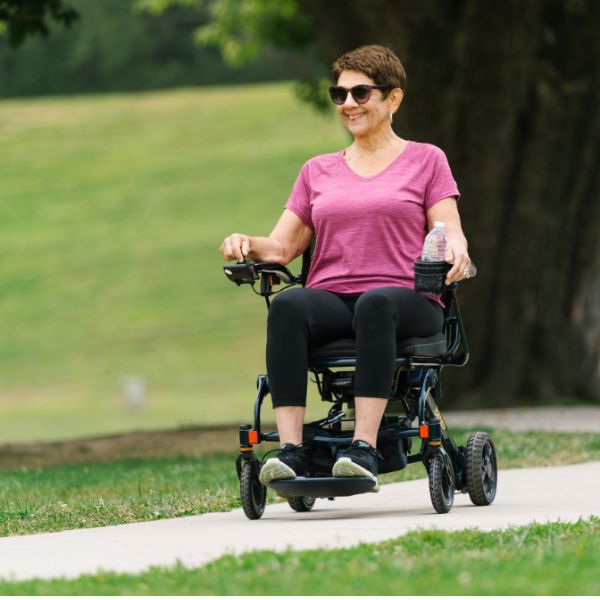 Woman using a Pride Jazzy Carbon 27 power chair in a park