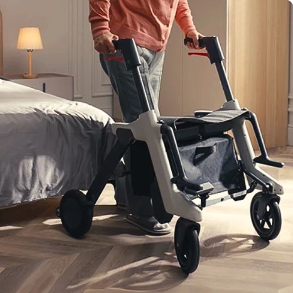 A person in a bedroom using a Roamate 3-in-1 Rollator Transport Electric Wheelchair