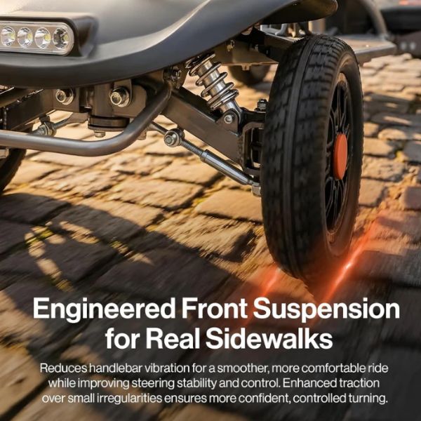 Close-up of the Superhandy Passport Flex 4-Wheel Mobility Scooter front wheel and suspension system on a stone surface with text about engineered front suspension.