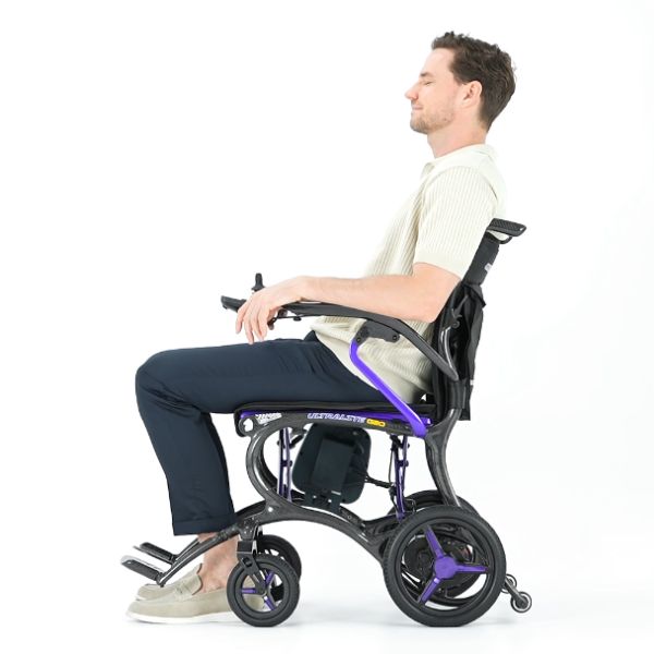 Man sitting in a Forcemech Ultralite G20 in Purple wheelchair on a white background