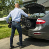 Image of Man putting the folded up Feather Lightweight Electric Scooter  in the back of a car's trunk