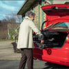 Image of Lady putting the Feather Lightweight Wheelchair in the back trunk of a car