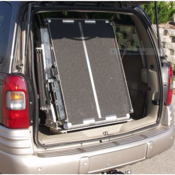 A folding rear door ramp mounted to the floor of a van, providing easy access for wheelchair users.